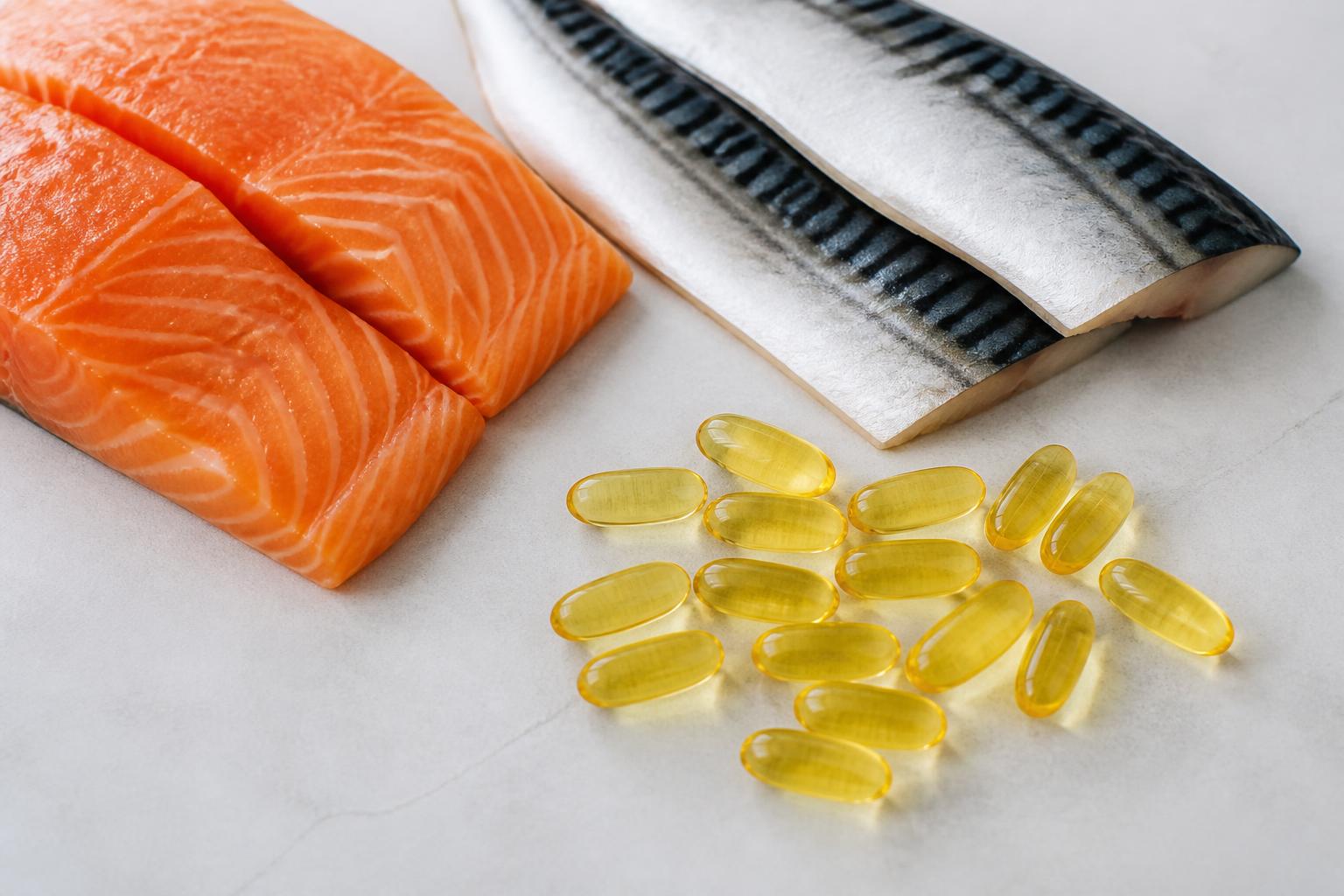 Oily fish and omega-3 capsules containing EPA and DHA.