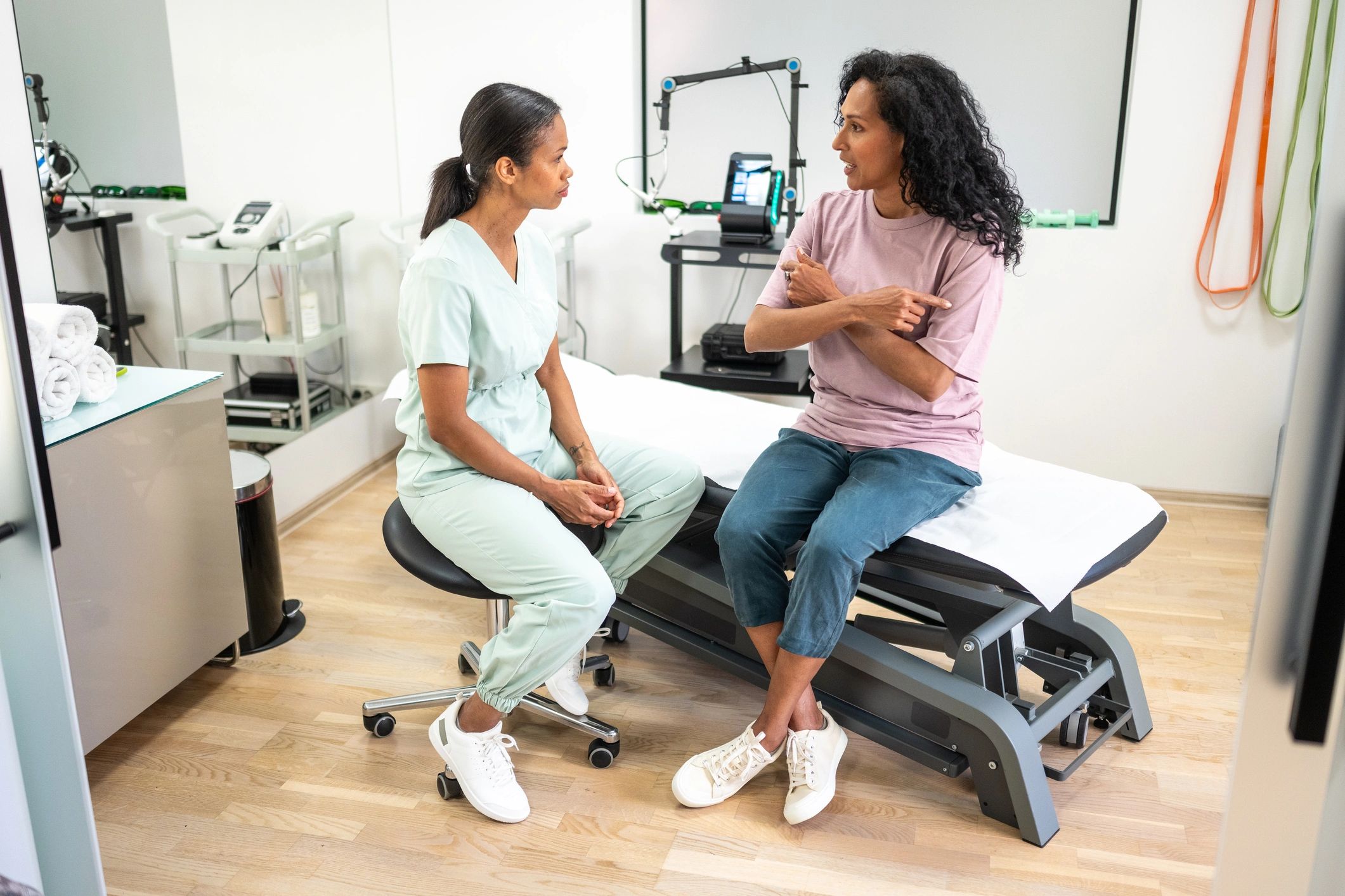 Physical therapist assisting a patient with shoulder mobility in a clinic